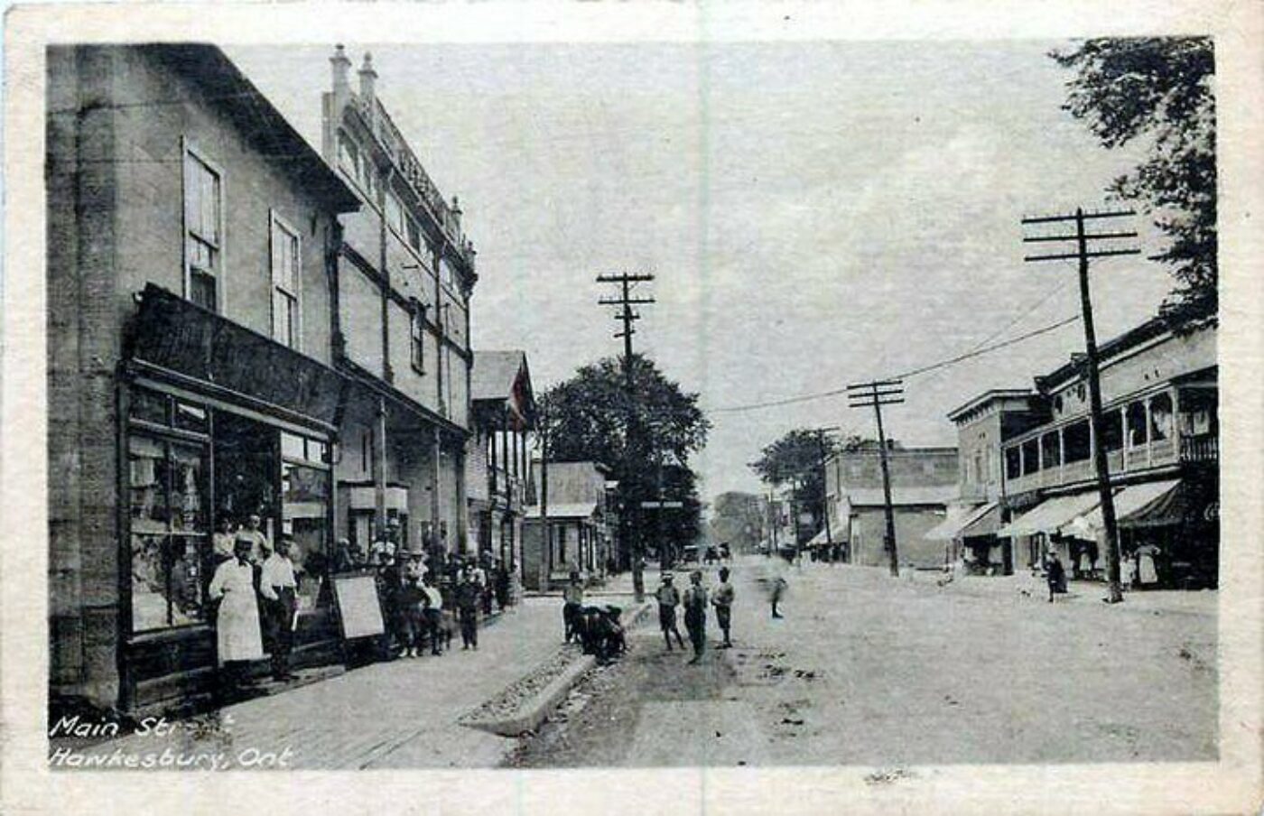 Photo de la rue principale avant 1955.  Cette photo montre le magasin Rubenstein. On remarque des rues en terre et les habillements du temps.